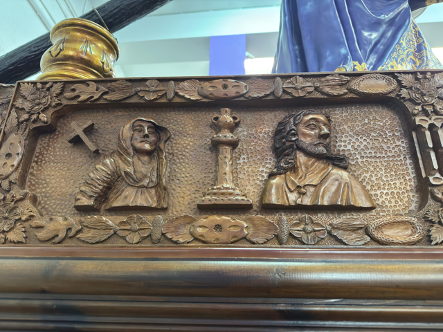 Y detrás, la Cruz , La Virgen María, y Jesús.